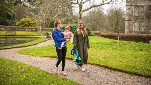 Family walking along a gravel path in the Upper Garden at Cotehele, Cornwall